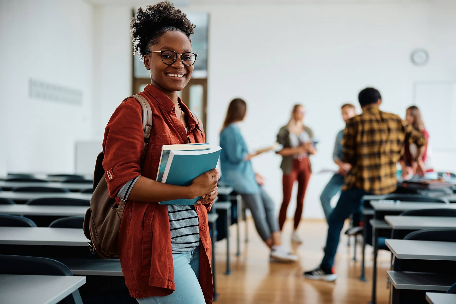 Happy black female student in the classroom looking at camera.